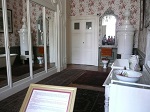 Łazienka różowa w apartamencie gościnnym pełniła również funkcję garderoby, dlatego całą ścianę południową zajmuje biała szafa z lustrami na drzwiach.
